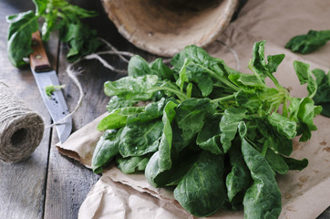 Fresh spinach in a old ceramic pot on wooden table