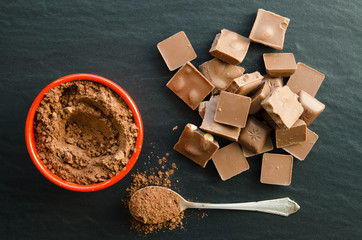 Chocolate bars with heap of cacao powder