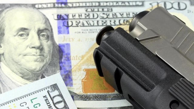 Hand Gun with American Currency - Hundred Dollar Bill Financial Security concept