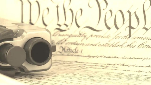 US Constitution Bill of Rights with hand gun - History of the Second Amendment