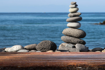 Holzauflage vor Steinturm mit Meerblick