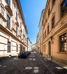 Obraz premium Narrow empty street with parked cars in Krakow, Poland.