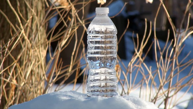 Freezing plastic bottle of water in real time frame. Low temperature and wind chills of -30F freezes this bottle of water in just few minutes. Actual outdoor temperature was 3F.