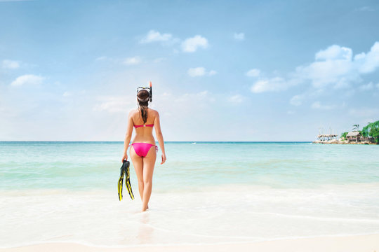 Rare view of hot, sexy woman going diving with snorkeling mask and flippers.