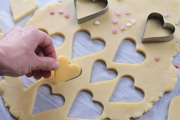 St. valentine's day cookies. Woman making heart shaped cookies close up.