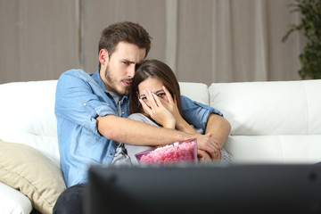 Couple watching terror tv movie at home