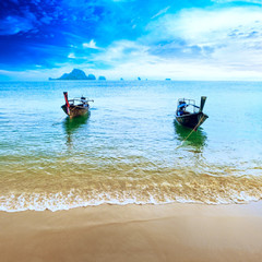 Travel boats on Thailand beach. Tropical coast landscape background