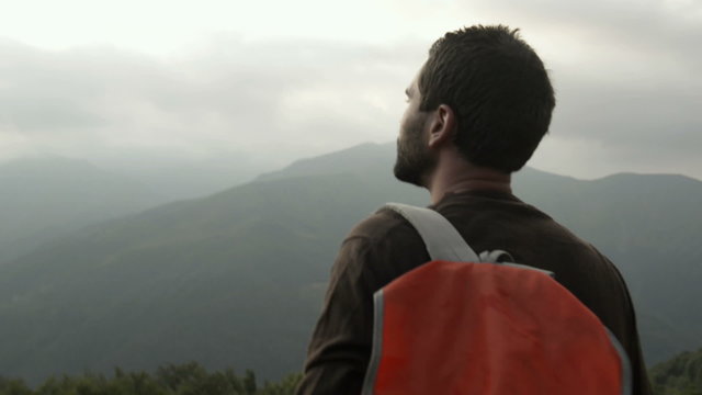 Man on mountain is watching panorama in overcast day   