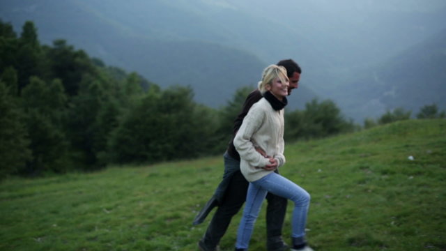 Young beautiful romantic couple is walking outdoor on mountain   
