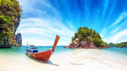 Amazing nature and exotic travel destination in Thailand. Thai tourist boat on white sand beach of small tropical island