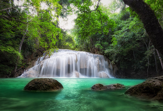 Waterfall in tropical forest. Jungle trees and blue water of mountain river in national park in Thailand
