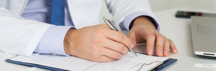 Close up of doctor's hands writing prescription
