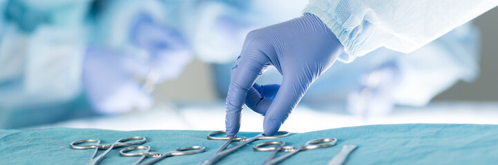 Close-up of scrub nurse taking medical instruments - obrazy, fototapety, plakaty