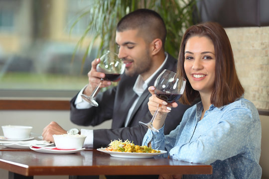 Happy young couple drinking wine while having a lunch in a restaurant