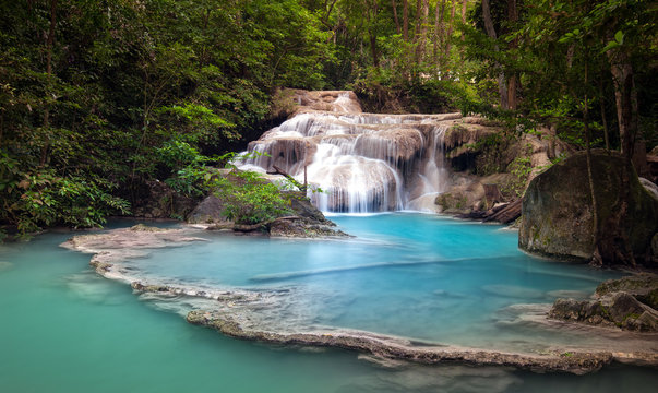 Mountain river stream flows through tropical forest and falls from cascades and waterfalls in wild lake with blue water © Banana Republic