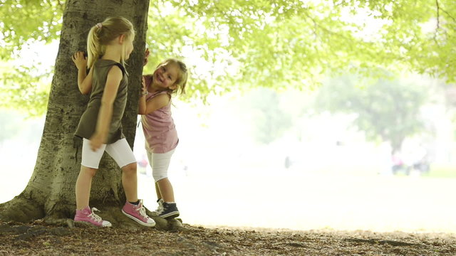 Sisters are playing hyde and seek at town park