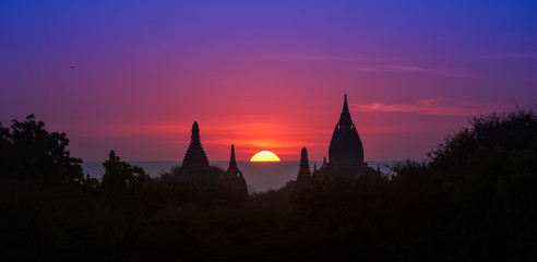 Ancient historical site Bagan in Myanmar at majestic sunset with beautiful sky and sun disk - 99872710