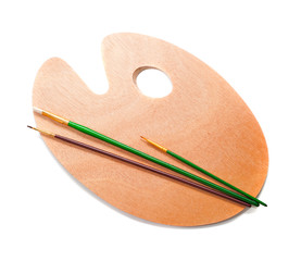 Art palette and paint brushes isolated on white background