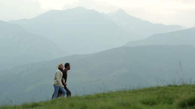 Young romantic couple is walking outdoor on mountain   