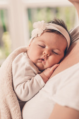 Portrait of sleeping baby in home and window is behaind