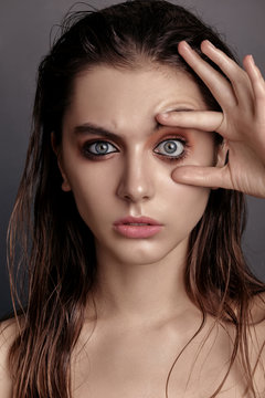 a young woman opens her eyes in studio