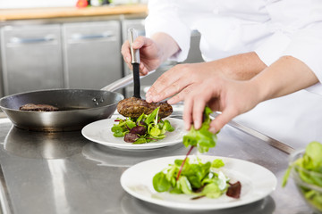 Obraz na płótnie Canvas Professional chefs prepares steak dishes at restaurant