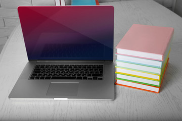 Stack of books with laptop on table close up