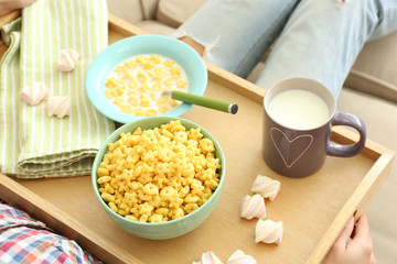 A girl with a tray having lunch on a sofa, close-up
