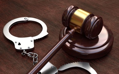  Gavel and handcuffs on wooden table background