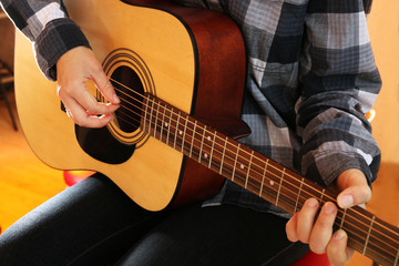 Guitarist plays guitar in the studio, close up