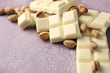 White chocolate pieces with nuts on color wooden background