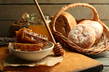 Honeycombs on plate, hot buns on wooden background