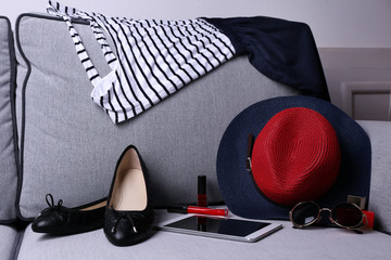 Composition of woman's fashion look on a gray couch
