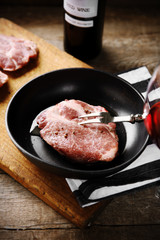 Marbled beef steak and wine bottle on wooden background