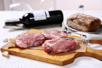 Marbled beef steak with bottle of wine and spices on wooden background