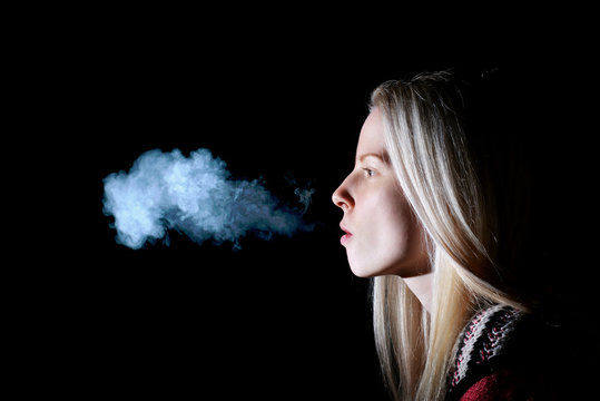 Woman Smoking a Cigarette on Black Background