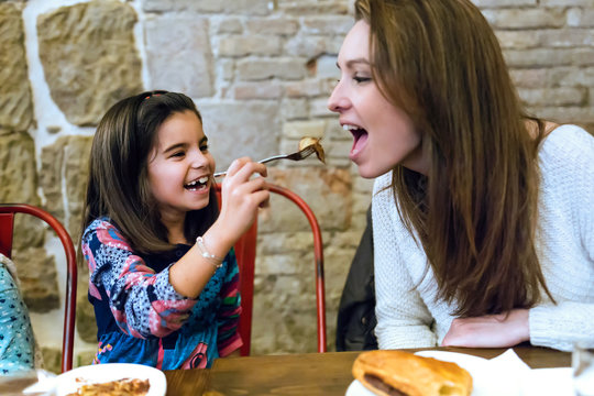 Happy Young Family Having Breakfast In The Cafe.