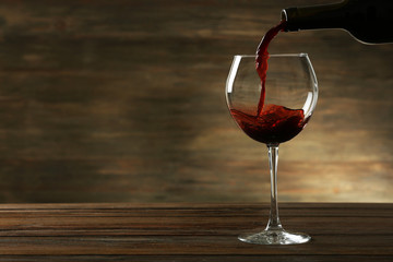 Fototapeta na wymiar Red wine pouring in a glass