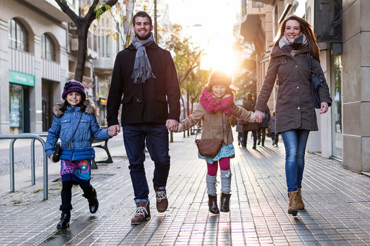 Happy Young Family Having Fun In The Street.