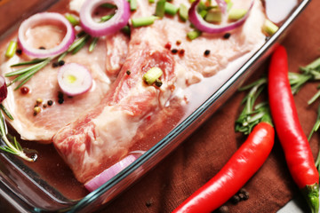 Marinating meat with spices on table, close up