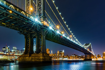 Fototapeta na wymiar Night view of Manhattan Bridge framing Freedom Tower through the southern pillars