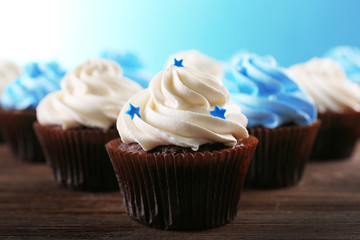 Chocolate cupcakes on wooden table in front of blue background