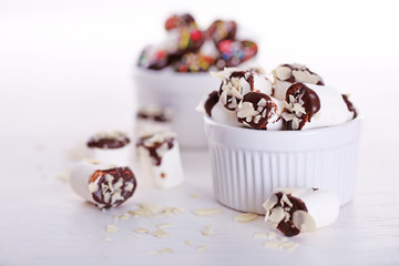 Tasty marshmallows with chocolate in bowl on table, close up