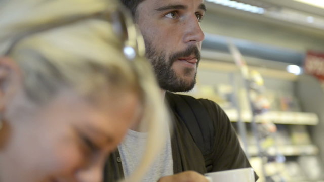 Young beautiful man have breakfast with cappuccino at service station   
