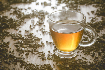 Green tea transparent cupon wooden table.