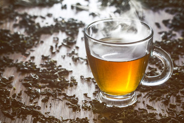 Green tea transparent cupon wooden table.