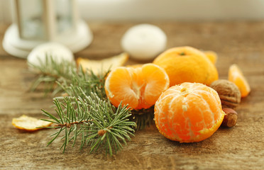 Beautiful still life with tangerines and fir-tree, on old wooden table, close up