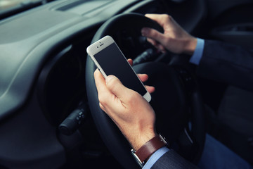 Man driver using smart phone in car