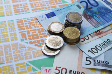 Euro coins and banknotes on map background