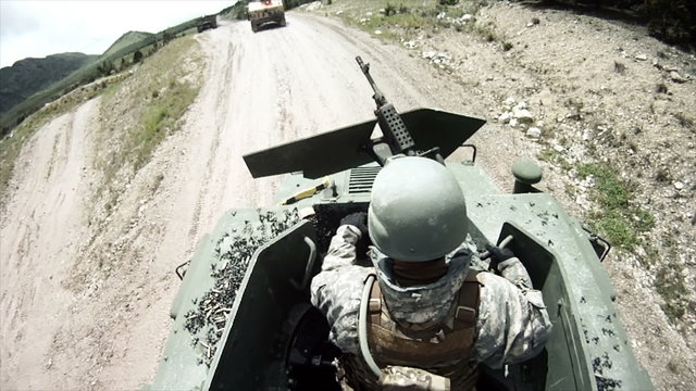 Soldier telling humvee driving there is a shortage of ammo